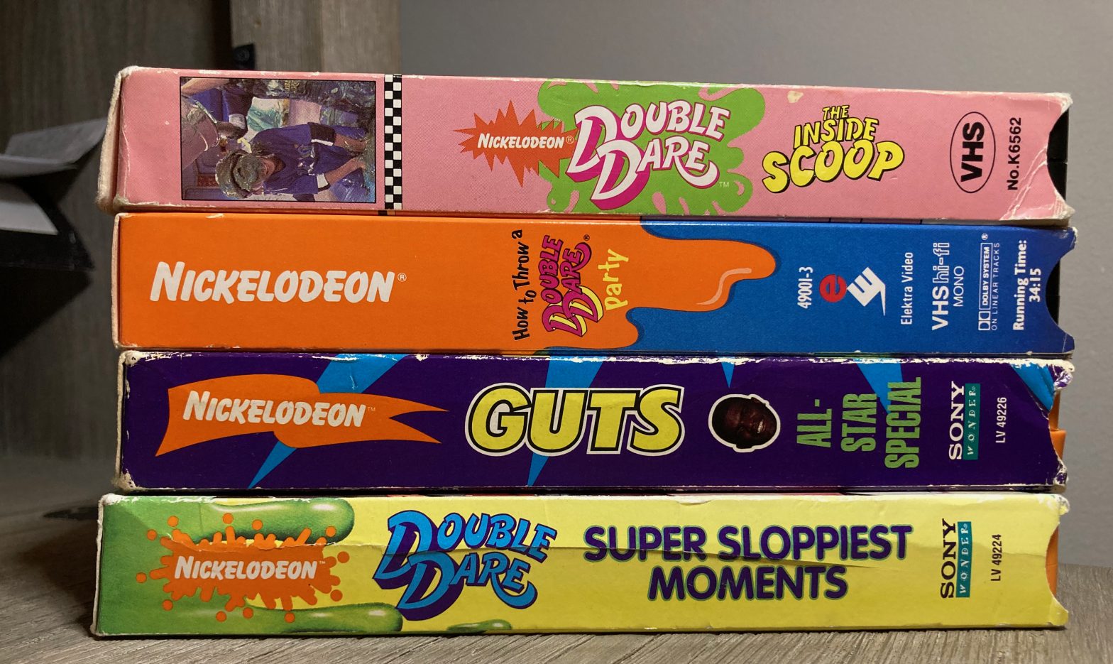 Four VHS tapes in a stack showing labels on long and skinny side of each box